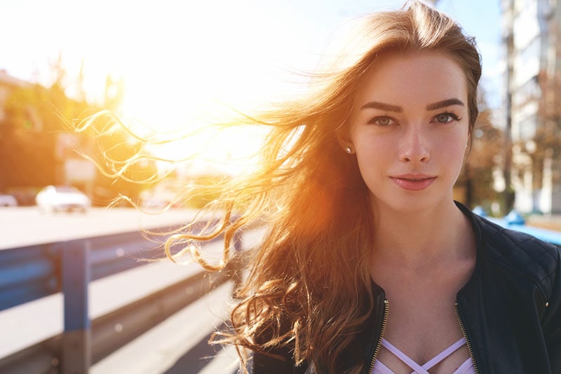 bonita mujer de pie bajo la luz del sol