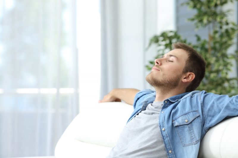 relaxed man sitting on sofa