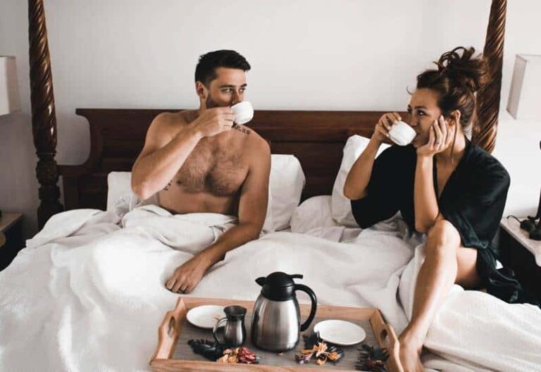 bella coppia che prende un caffè sul letto e parla