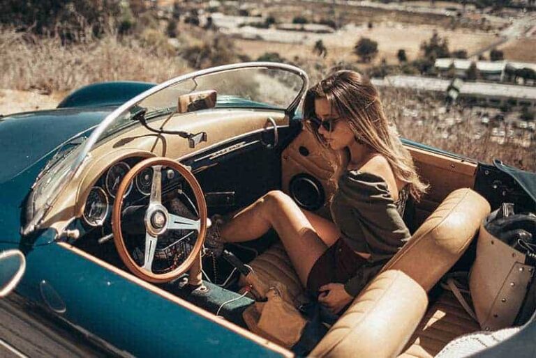 joven hermosa mujer con gafas de sol y sentado en el coche