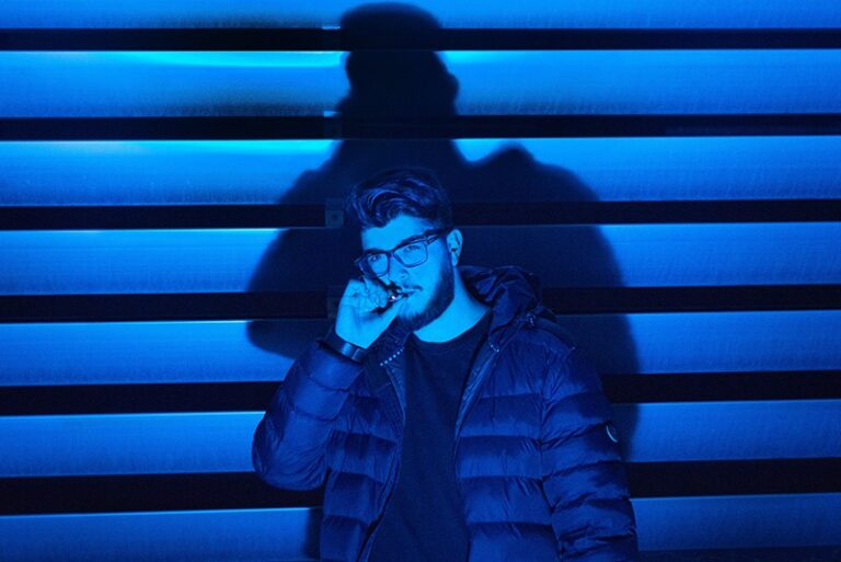 blue effect photo of man wearing eyeglasses and smoking cigarette