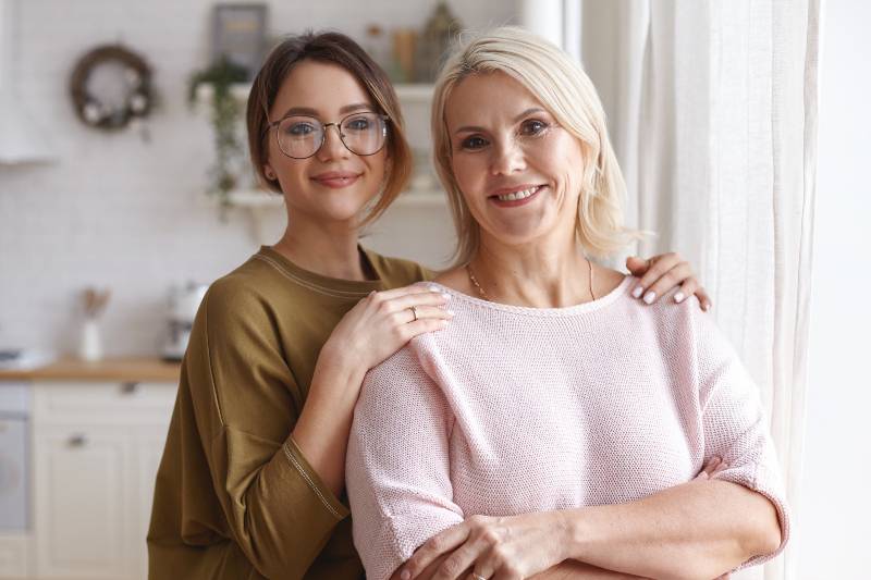 Portrait of daughter and mother with glasses at home
