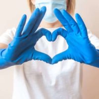 nurse hands in blue gloves in the shape of heart