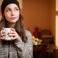young mindful woman drinking coffee
