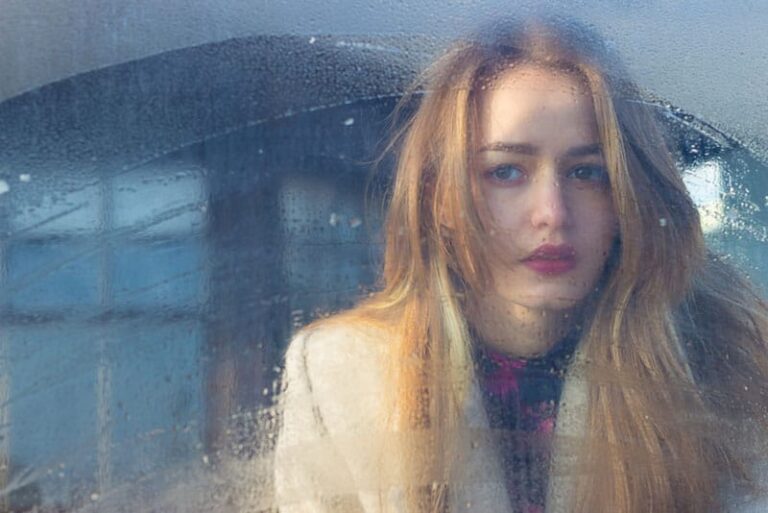 sad woman looking through the window