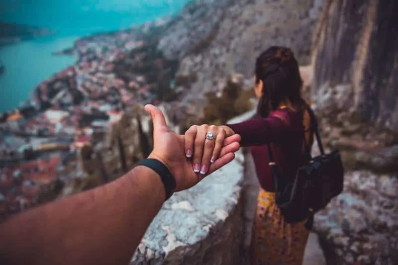Woman holding man's hand while looking at the landscape of the building