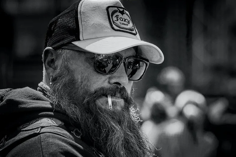 a man with a beard and a cigarette in his mouth