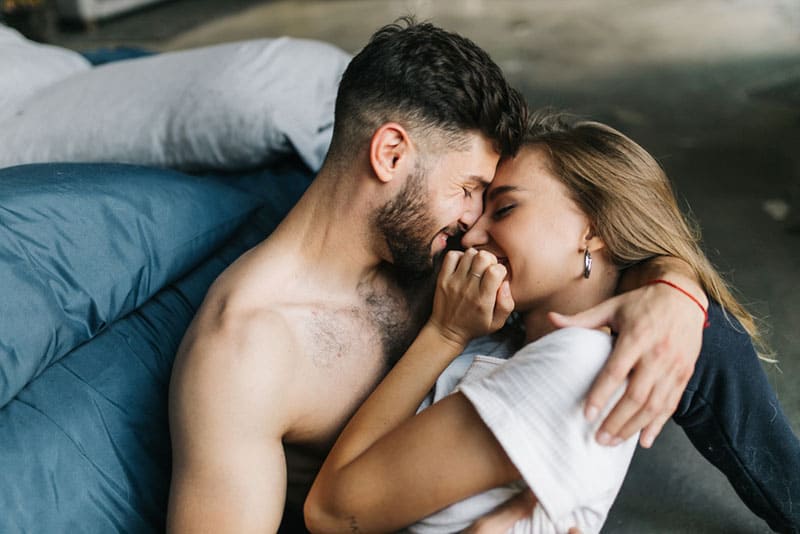 couple cuddling and kissing on the floor