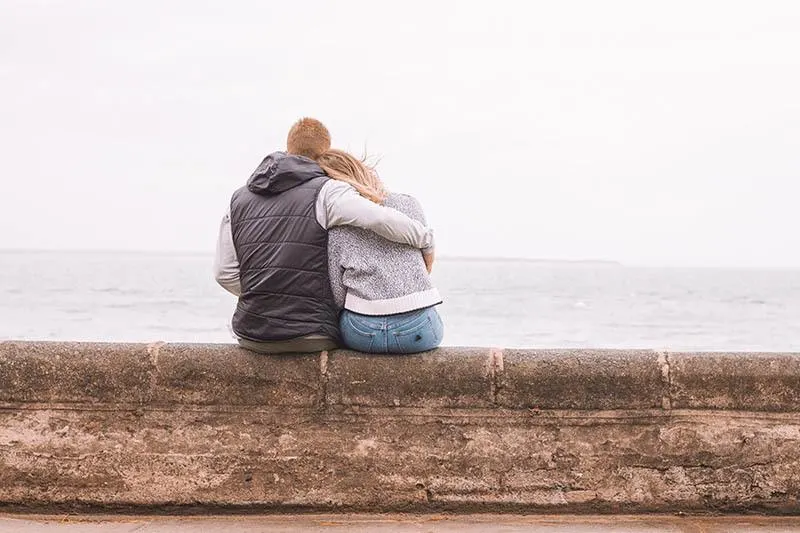couple hugging in front of sea