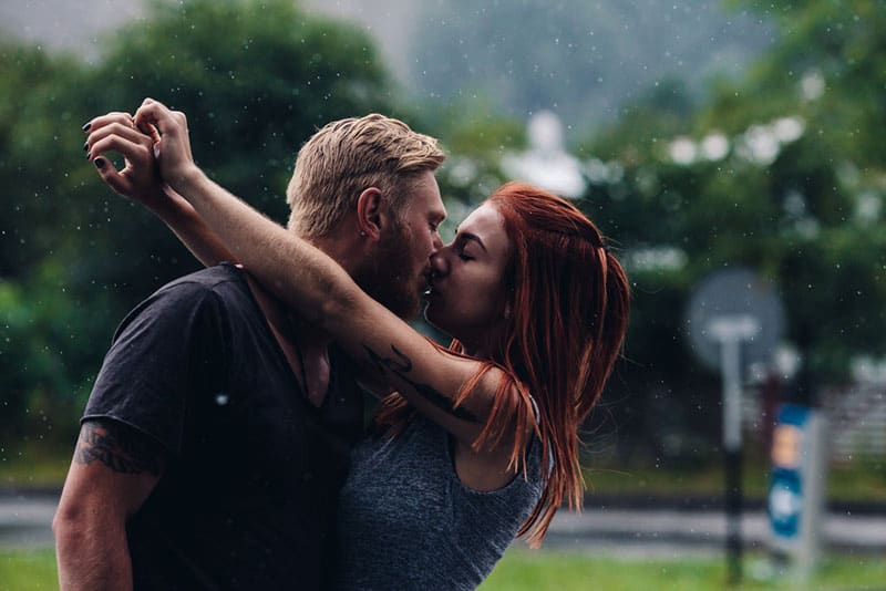 couple kissing on the rain