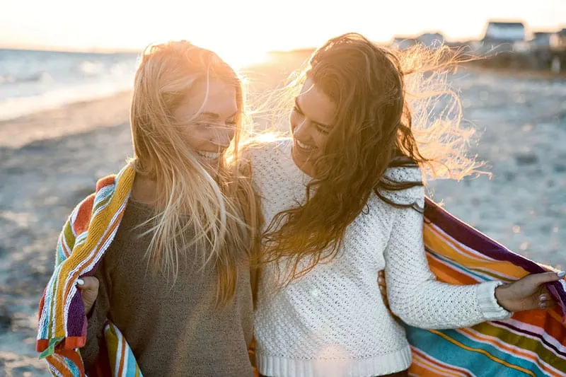 two friends walking on the beach
