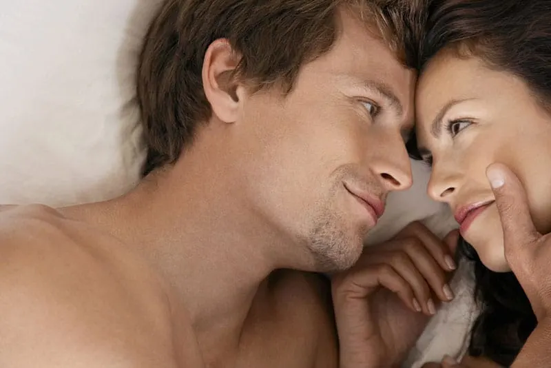 woman and man looking at each other in bed