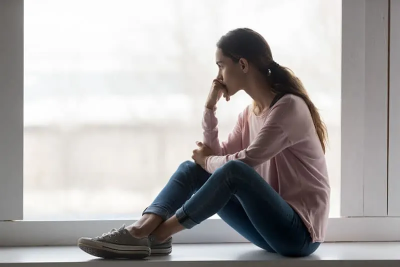 worried woman sitting by the window
