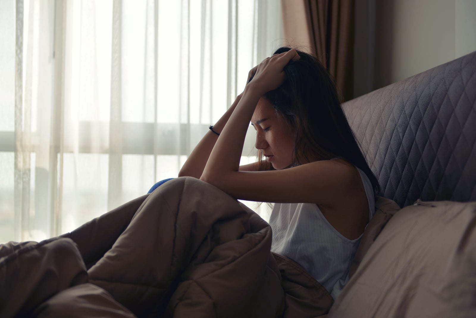 worried woman sitting in bed