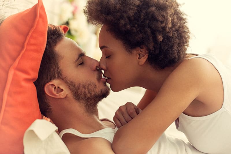 young couple kissing on the bed