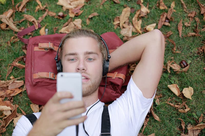 young man listening to music in the park
