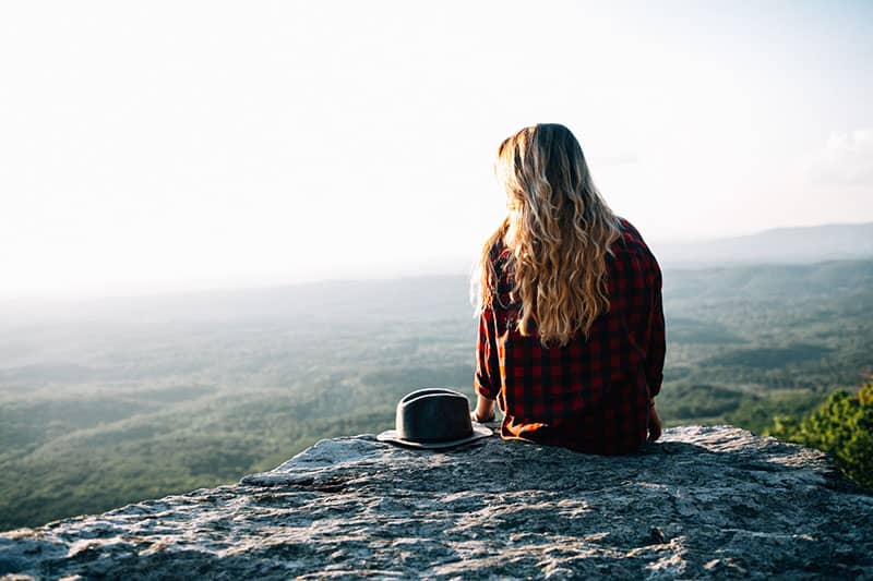 mujer joven sentada en la naturaleza