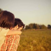 man carrying woman walking on grass field