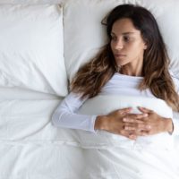 mujer preocupada tumbada en la cama