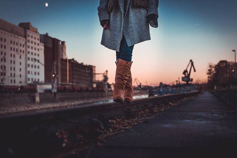 woman wearing boots and jacket and walking outside