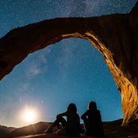 two female friends sitting and looking at stars