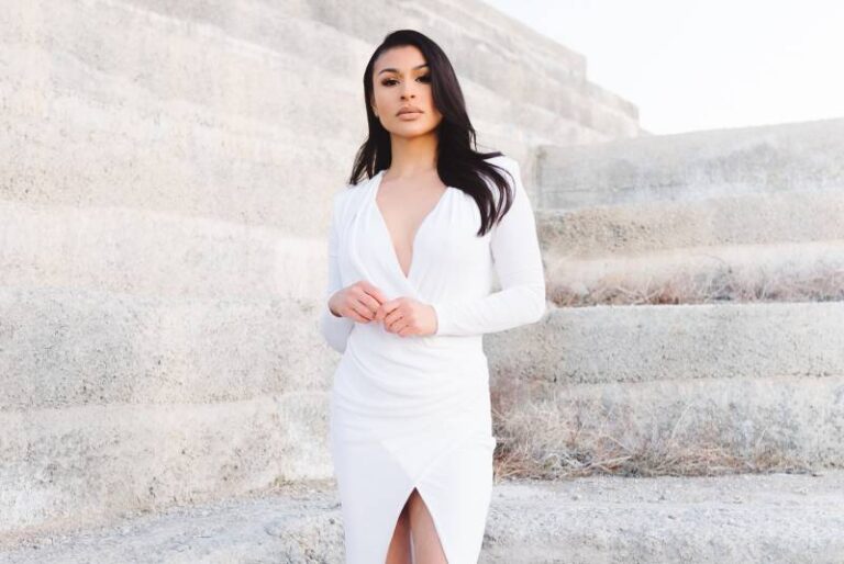 woman wearing white dress and standing beside wall