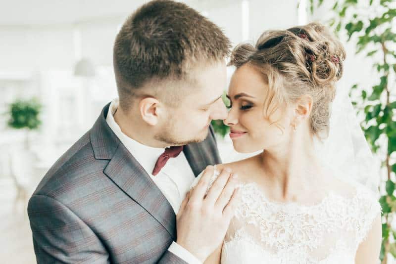 Felices y hermosos recién casados abrazándose en el restaurante