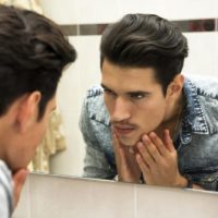 serious man looking at mirror