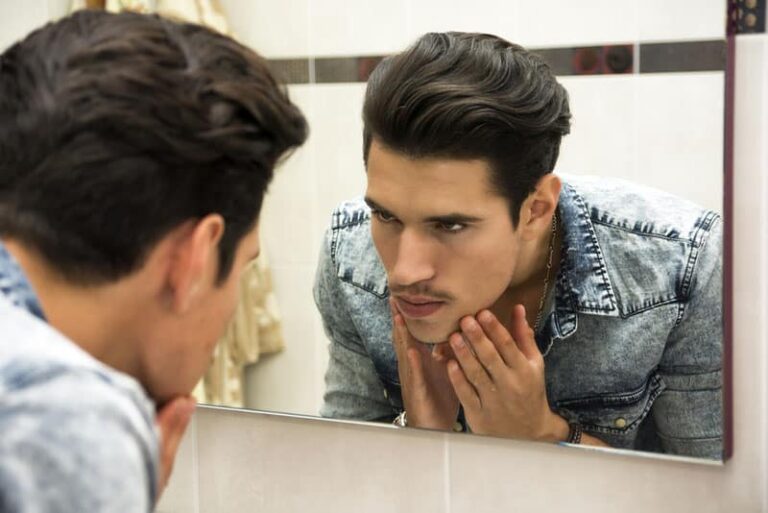 uomo serio che si guarda allo specchio