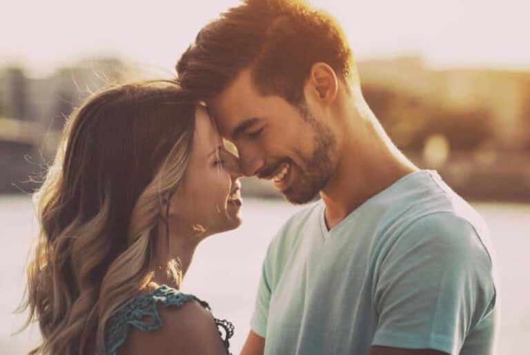 lovely couple standing beside lake