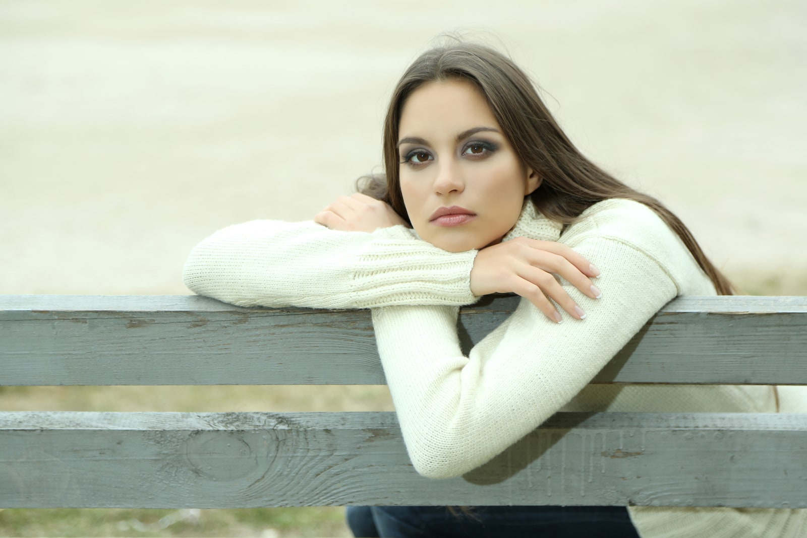 Mujer joven y solitaria en un banco del parque