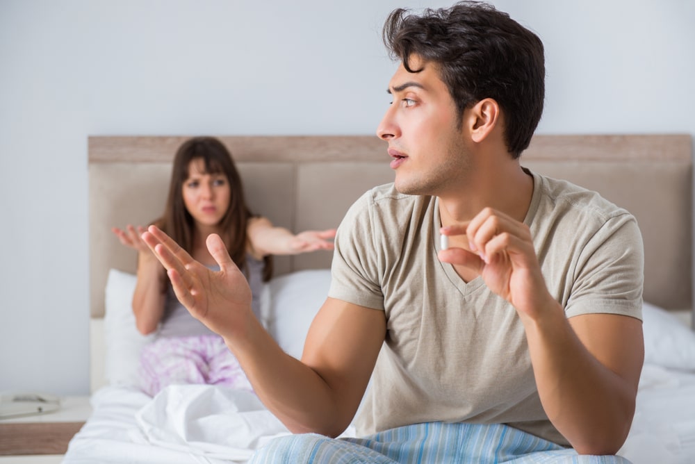 um homem discute com uma mulher na cama