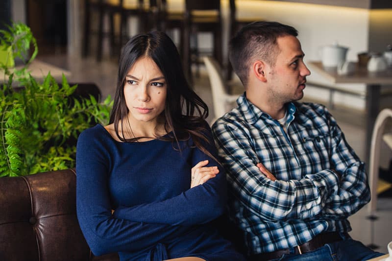 angry woman sitting next to her boyfriend