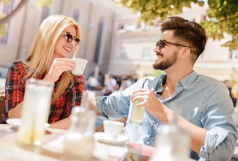 belo casal a conversar num café durante o dia