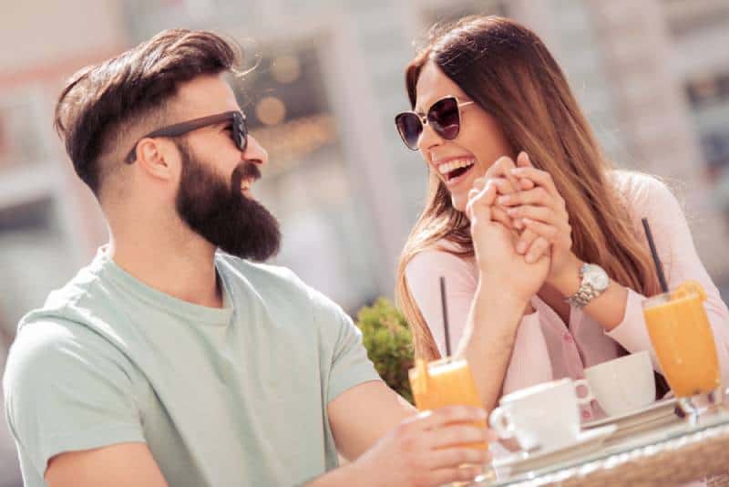 alegre pareja teniendo una cita en el café