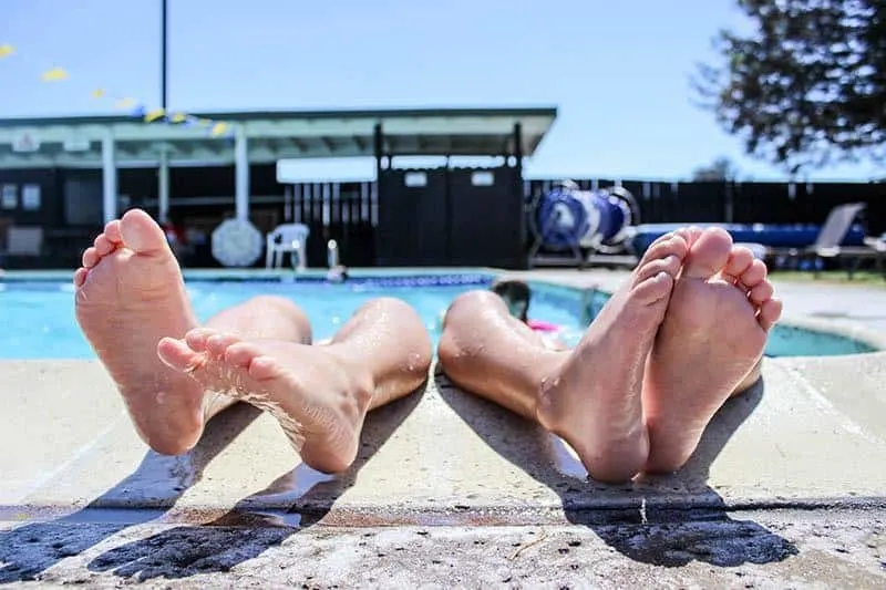 close up photo of persons feets on pool