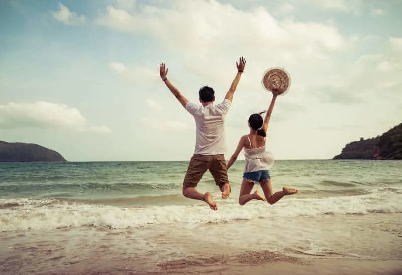 couple jumping on the sand beach