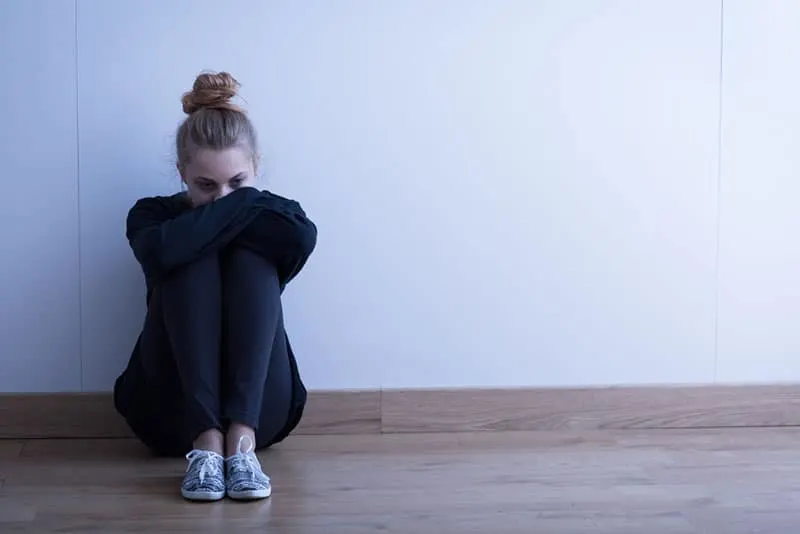 depressed woman sitting on the floor