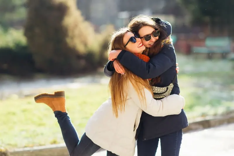 female friends hugging outside