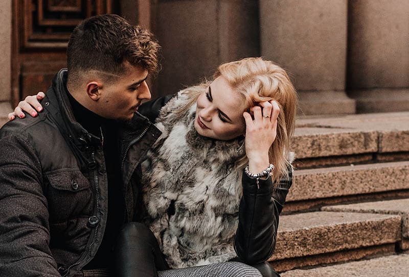 uomo e donna si guardano mentre sono seduti fuori