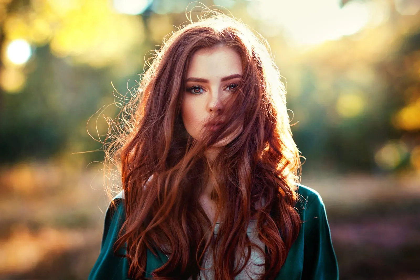portrait of a beautiful red-haired girl in the park