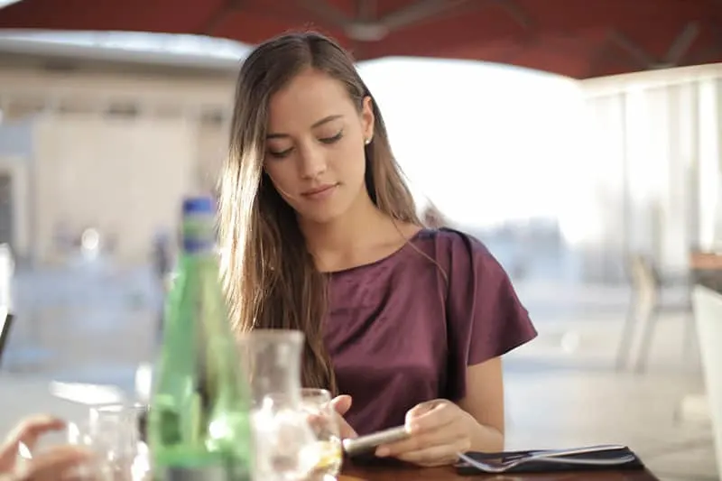 pretty woman texting in restaurant