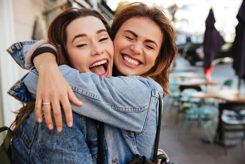 amigos sonrientes abrazados al aire libre