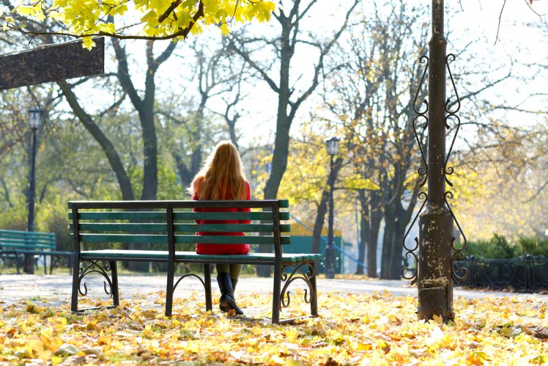 donna seduta su una panchina nel parco