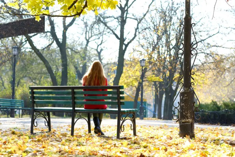 woman sitting on bench in park