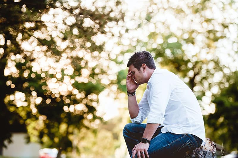 worried man sitting in the park alone