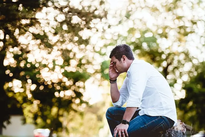 worried man sitting in the park alone