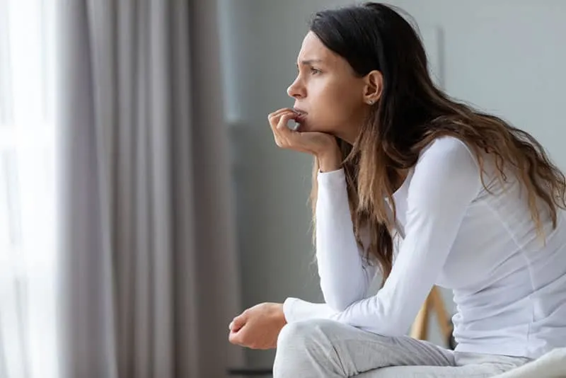 worried woman sitting in the bedroom