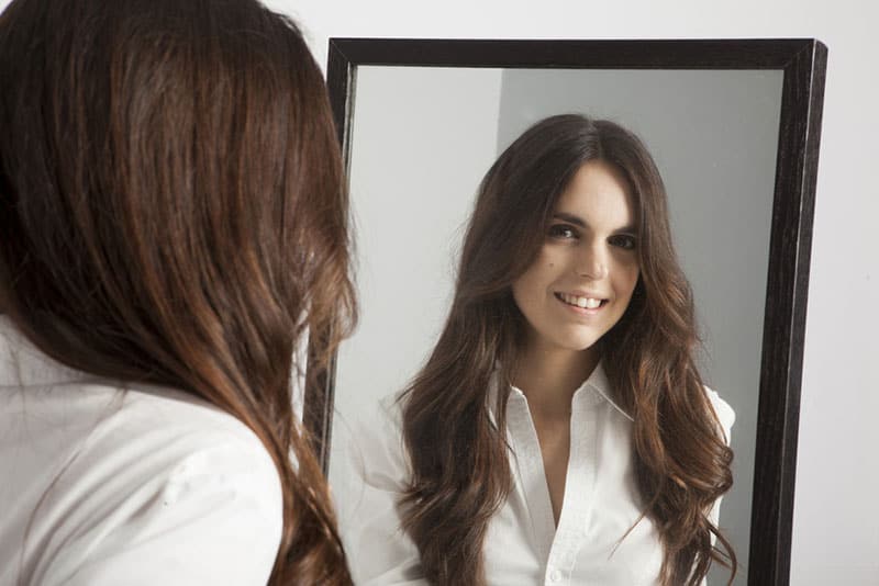 young woman looking at mirror