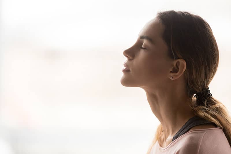 mujer joven respirando hondo